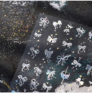 Vue macro d'autocollants 3D laser pour ongles avec nœuds et motifs célestes fins