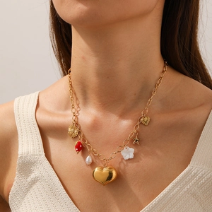Goldene Edelstahlkette mit Herz-, Perlen- und Seesternanhängern an einem weiblichen Model