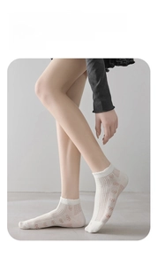 Detail of white cotton socks with breathable lace mesh and cute knitted patterns