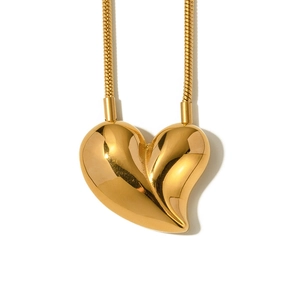 Macro shot of 18k gold plated asymmetrical heart pendant on a shiny snake chain necklace