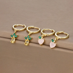 Gold pineapple and peach fruit hoop earrings with colorful zircon stones on display
