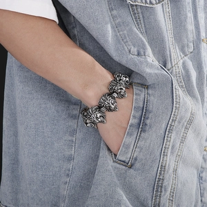 Close-up of vintage silver lion head link bracelet in punk style on male model wrist