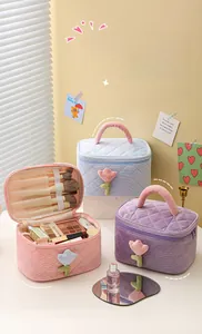 Inside look at a corduroy makeup bag with brush slots and flower detail on the exterior