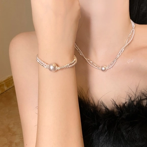 Elegant multi-strand pearl necklace and bracelet jewelry set worn by a female model