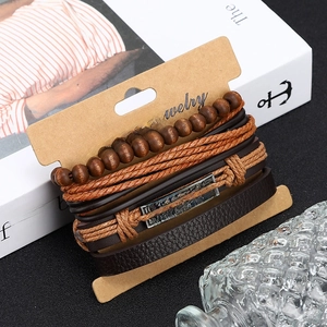 Détail de bracelets en cuir multicouches avec perles en bois et breloque gravée believe