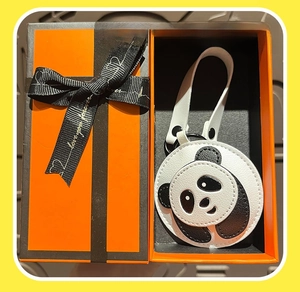 Detail of cute panda leather charm presented in a luxury orange gift box with ribbon