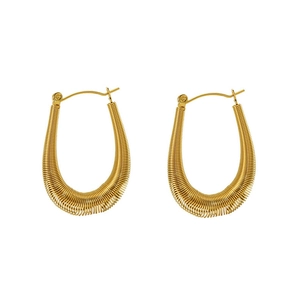 Detailed macro view of gold U-shaped hoop earrings featuring fine spiral spring texture