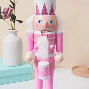 Detail of pink wooden nutcracker soldier with glitter hat and white drum decoration