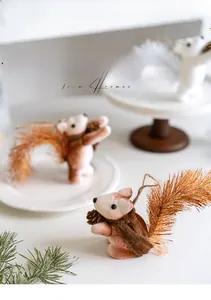 Détail de l'ornement d'écureuil de Noël avec flocage brun et accessoire de pomme de pin