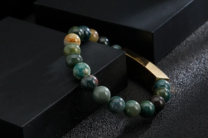 Close-up of multicolor agate beaded bracelet with gold stainless steel engraved bar