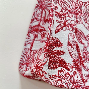 Macro shot of high-quality red and white Toile de Jouy jacquard fabric on a tote bag