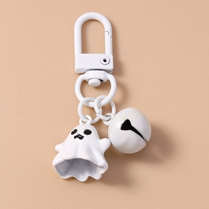 Close-up of a 3D white ghost keychain with a matching metal bell and ring attachment