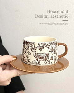 Detail view of a vintage ceramic coffee cup with deer patterns and matching saucer