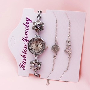 Silver-tone women's quartz watch and rhinestone bracelet set on pink background