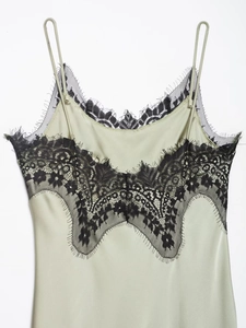 Detail of sage green satin camisole with black lace trim and delicate spaghetti straps