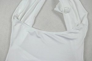 Detail of white halter neck dress featuring fine double-needle stitching and plain fabric
