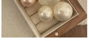 Macro shot of elegant cherry-inspired hair claw with lustrous pink and white pearls