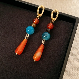 Details von Boho-Ohrhängern mit Türkisperlen und orangefarbenem Tropfenanhänger