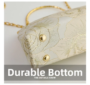 Detail view of champagne gold brocade evening bag with metal studs and rose pattern