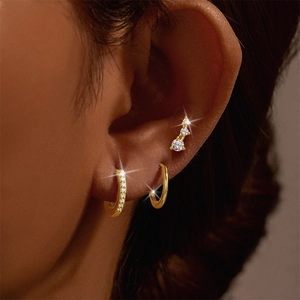 Macro shot of gold S925 sterling silver hoop earrings set with zircon studs on ear