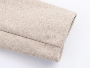 Detailed macro view of the soft beige wool blend fabric texture of the blazer
