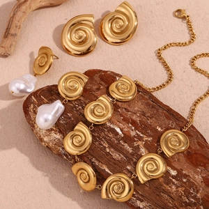 Detail view of 18K gold plated shell jewelry set with spiral necklace and pearl earrings