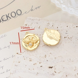 Macro shot of gold-plated bee pendant with cubic zirconia, DIY jewelry charm 17mmx15mm