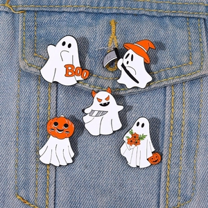 Close-up of five Halloween ghost enamel pins on a denim jacket pocket featuring pumpkin motifs