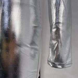 Gros plan sur le tissu métallique argenté et la couture de manche d'une robe moulante