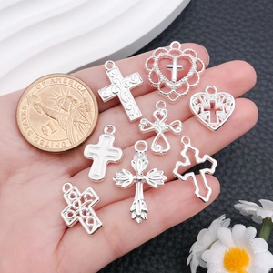 Detailed view of silver alloy cross pendants with a coin for size comparison and scale