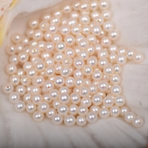 Macro view of 4mm AAAA white freshwater pearls with iridescent luster in a shell