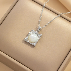 French luxury silver necklace featuring an irregular square frame and iridescent pearl pendant