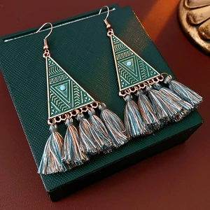 Detailed shot of bohemian triangle fringe earrings with dark green thread and gold alloy