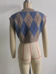 Detail of argyle knit vest featuring ribbed edges in grey-blue and latte tones