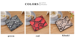 Three men's snake skin pattern wallets in green, red, and khaki on a wooden desk