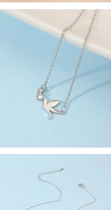 Macro shot of silver swallow bird pendant with white cubic zirconia on a delicate chain