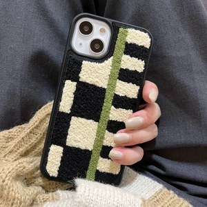 Detail of plush checkerboard pattern iPhone case with green fuzzy stripe texture