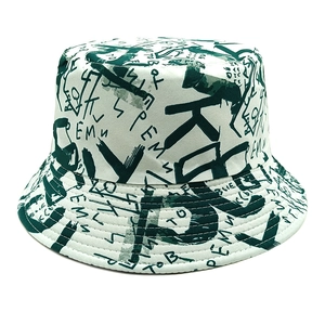 Detailed view of canvas bucket hat with dark green graffiti lettering and stitched brim