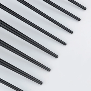 Detailed macro view of black brush bristles with smooth rounded tips on a white background