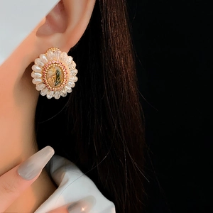 Macro view of vintage crystal flower earrings with rose pink petals on model's ear