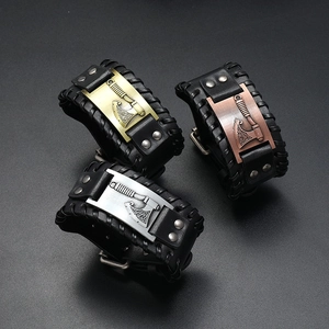 Trois bracelets viking en cuir avec hache en métal doré, argenté et bronze sur fond noir
