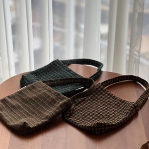 Detailed view of plaid tweed tote bags with distinct woven textures and retro colors