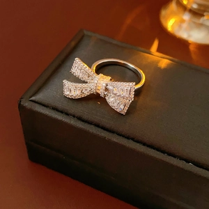Detail of silver bow ring with sparkling zircon stones on a black leather jewelry box