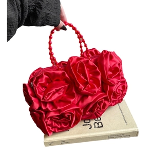 Elegant red rose-shaped evening handbag with matching beaded handle on white background