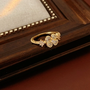 Detail of gold flower ring with heart petals, zircon pavé, and beaded edges