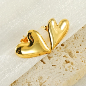 Detailed close-up of 18K gold-plated 3D heart earrings on elegant textured background