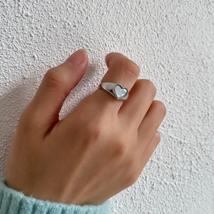 Close-up of 925 sterling silver heart ring with white mother of pearl inlay on finger