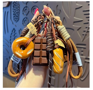 Detail of cute pretzel bread keychains with woven ropes and assorted food pendants