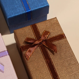 Macro detail of luxury rectangle gift boxes with textured paper and ribbon bow