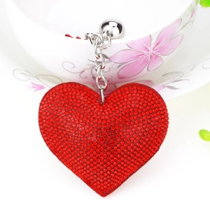 Close-up of red heart keychain with sparkly rhinestones, metal chain and round bell